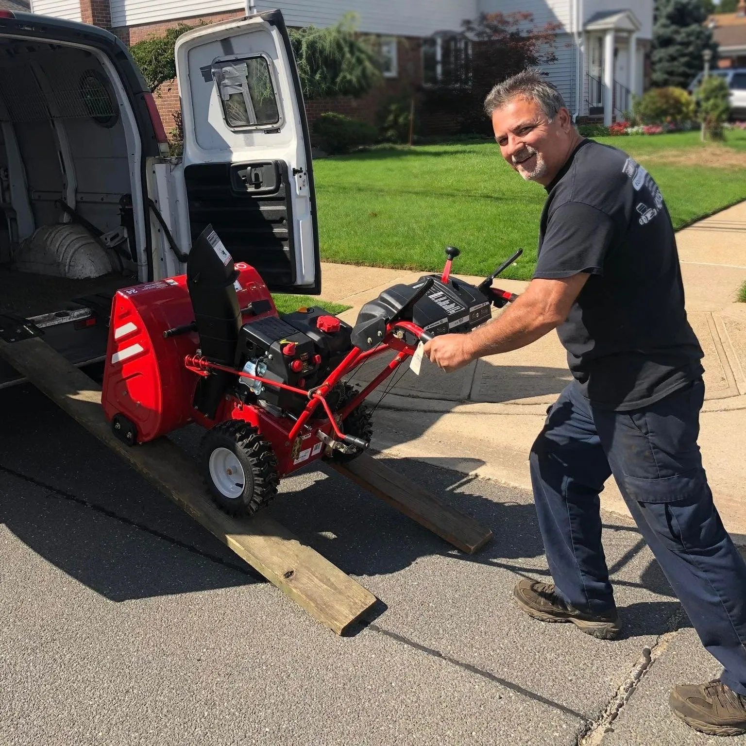 Pete loading a snowblower into the pickup van